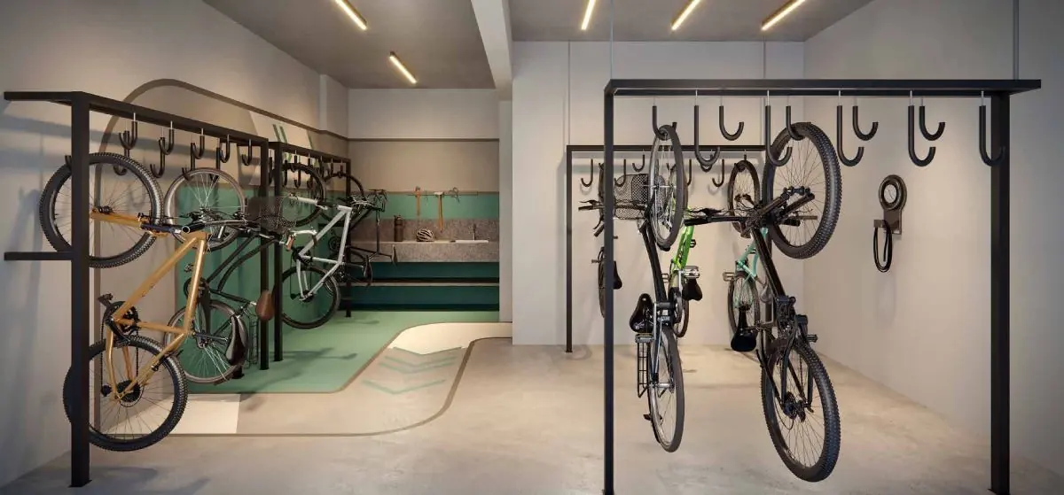 O bicicletário com as bicicletas penduradas em suportes de parede.