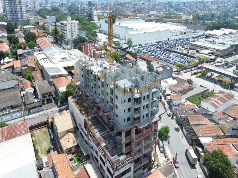 A torre em obra de perto, com a estrutura de concreto e a rua ao lado.