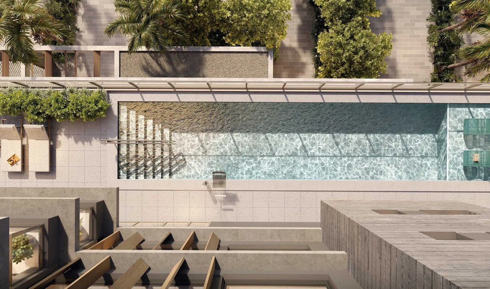 A piscina descoberta com o deck molhado, o solário e os bancos de concreto entre a vegetação.