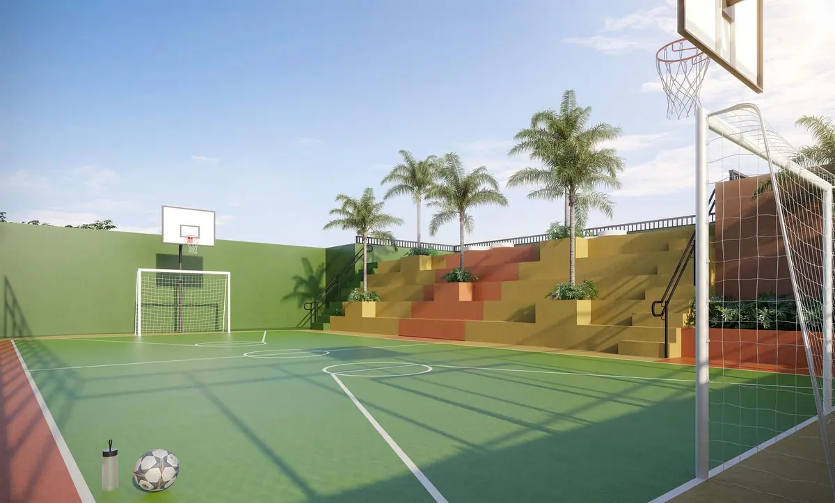 A quadra recreativa de piso verde, com tabela de basquete, gol e uma arquibancada colorida.