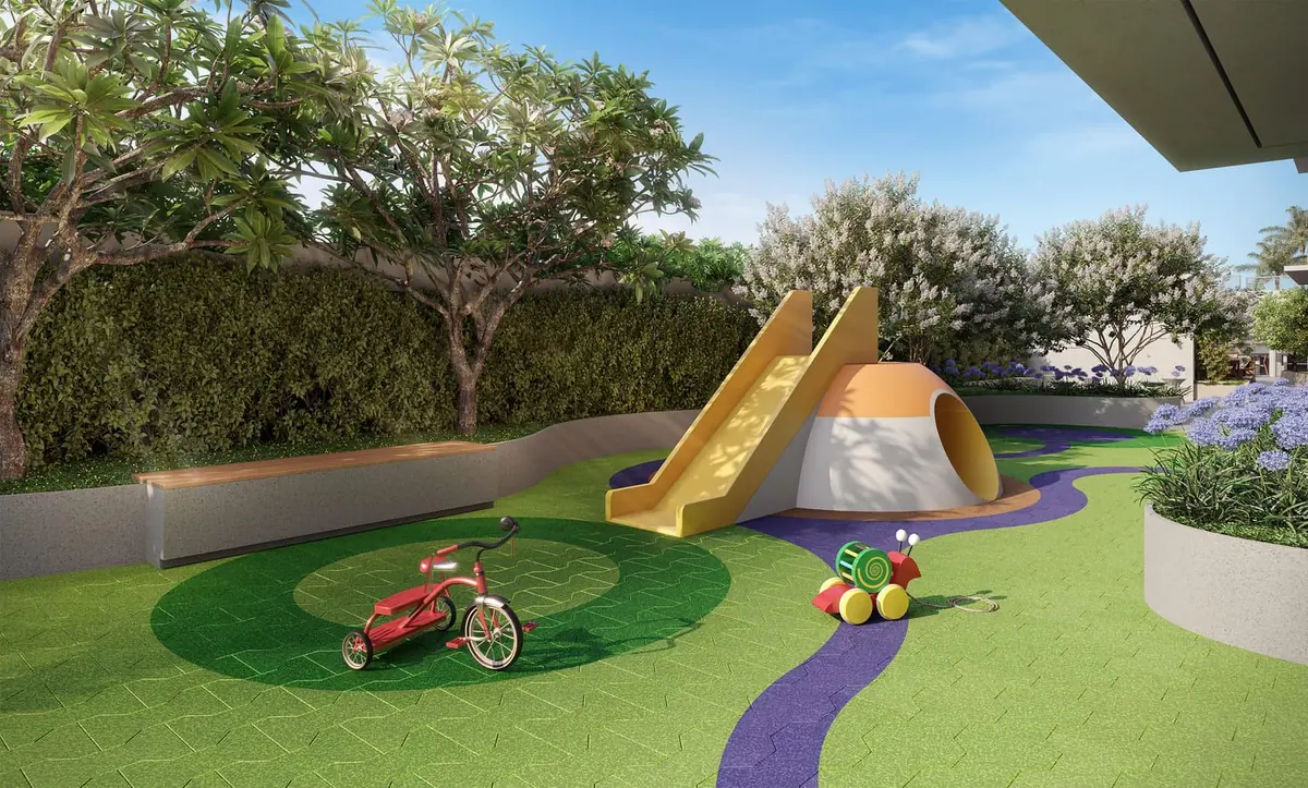 O playground no gramado, com um escorregador amarelo, um triciclo e um caminho lilás.