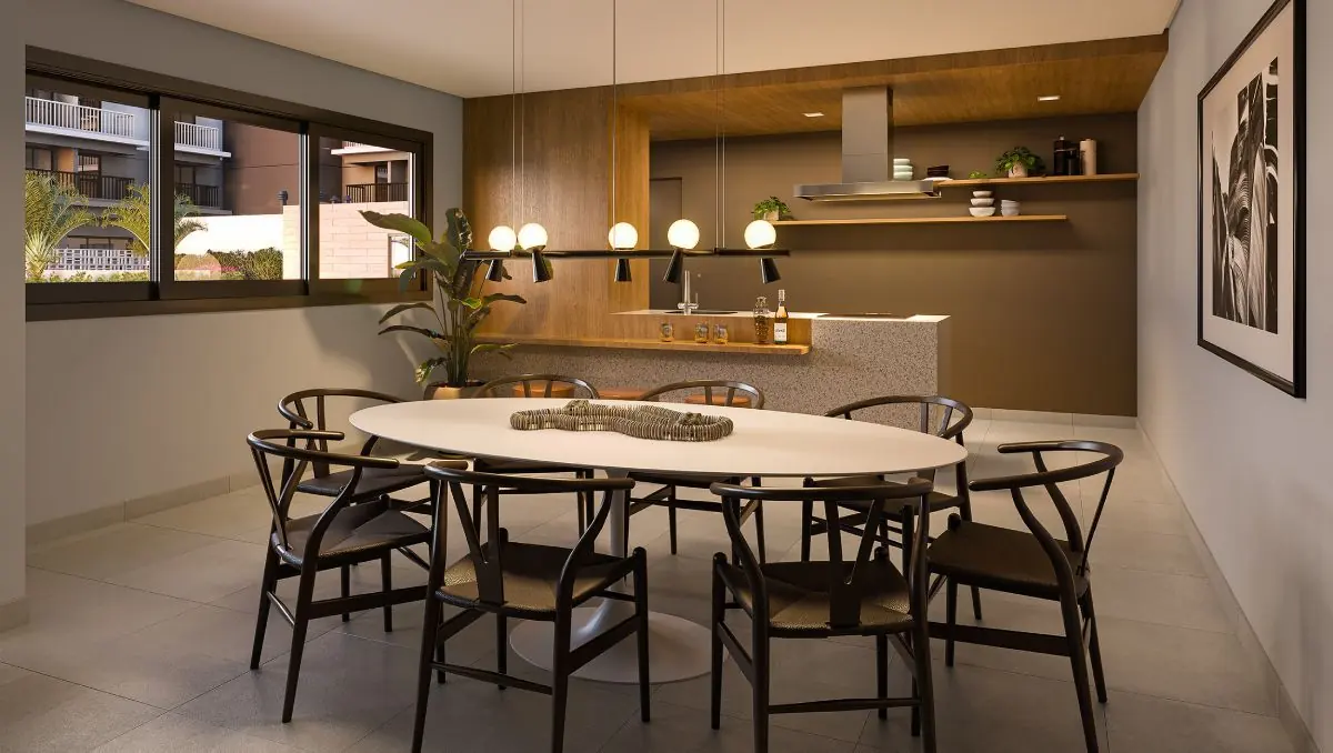 A área gourmet com a cozinha aberta e uma mesa redonda.