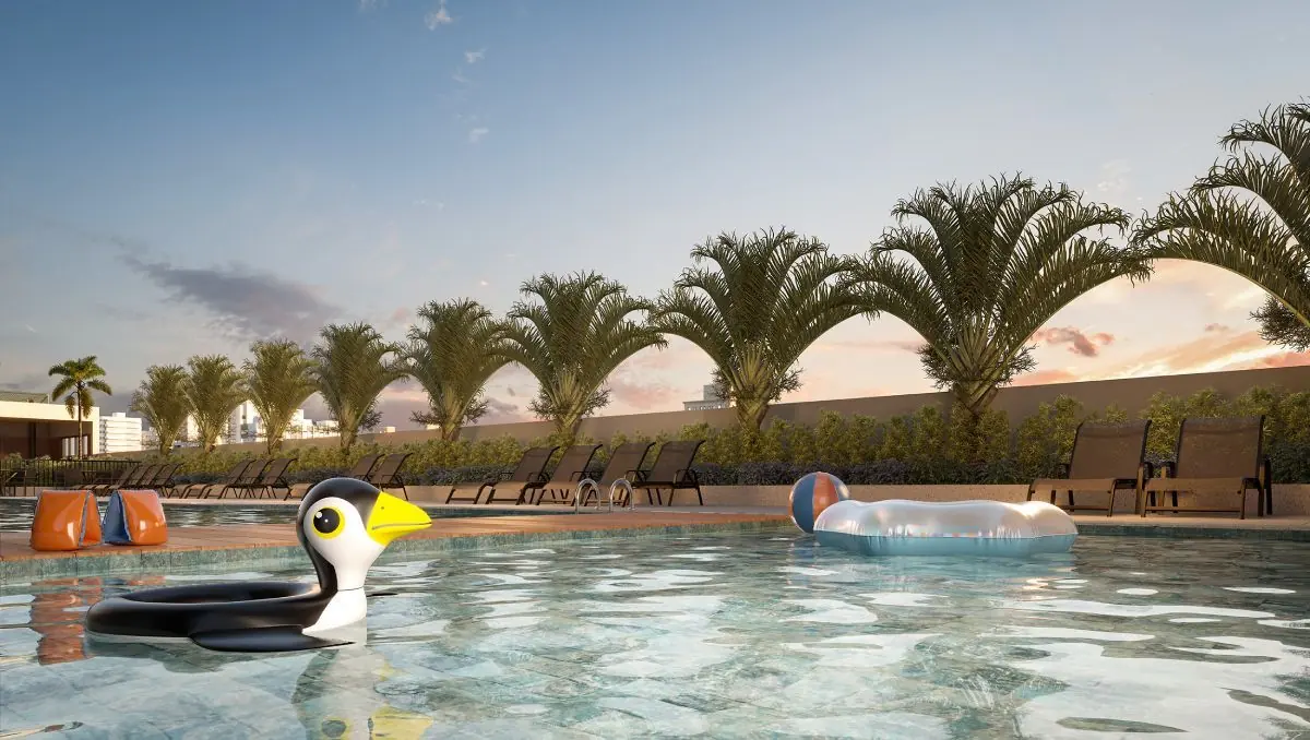 A piscina infantil, rasa, com uma boia de pinguim na água.