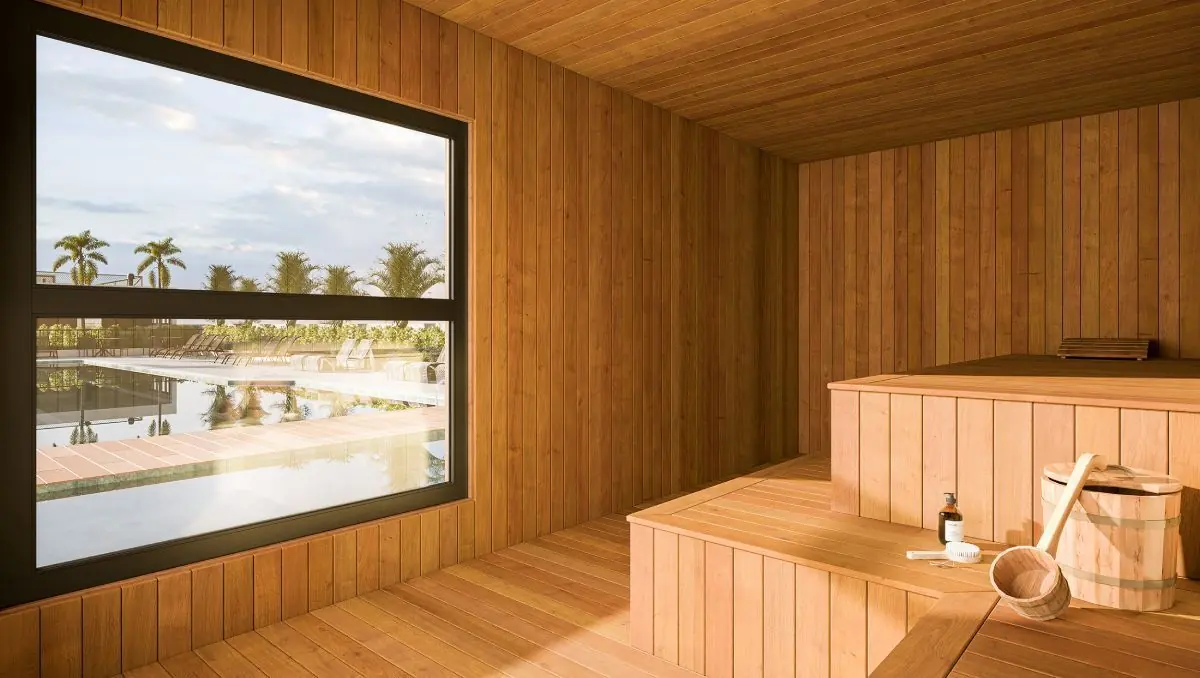 A sauna seca revestida de madeira, com uma janela larga.