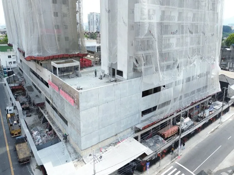 O embasamento do MOB Shopping em obra, de perto, com as telas de proteção nas torres.
