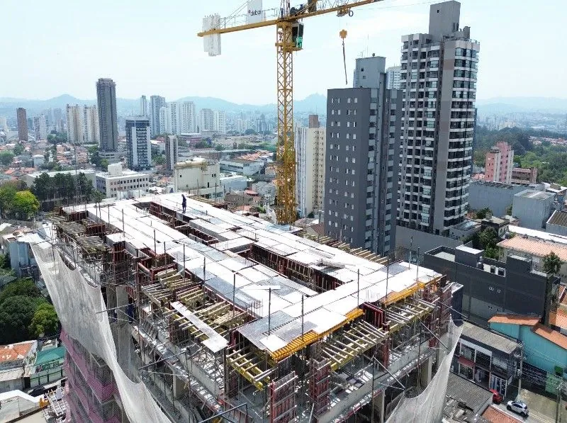 O topo da torre em obra, com a grua amarela e os prédios de Osasco em volta.